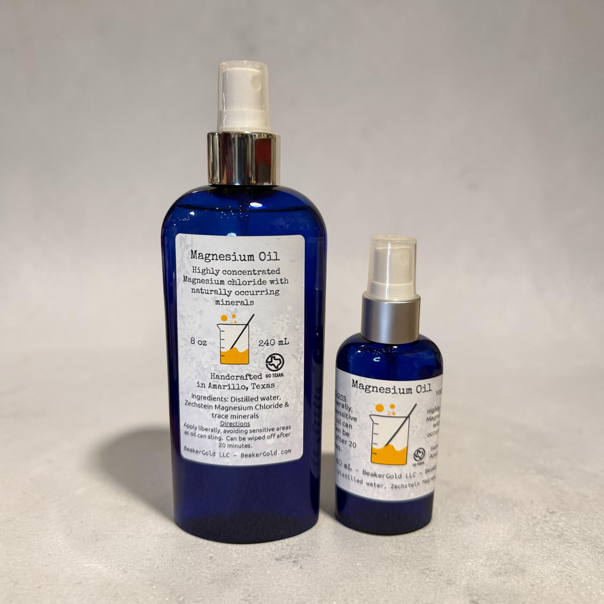 Two bottles of natural Zechstein Magnesium Oil Spray on a concrete surface